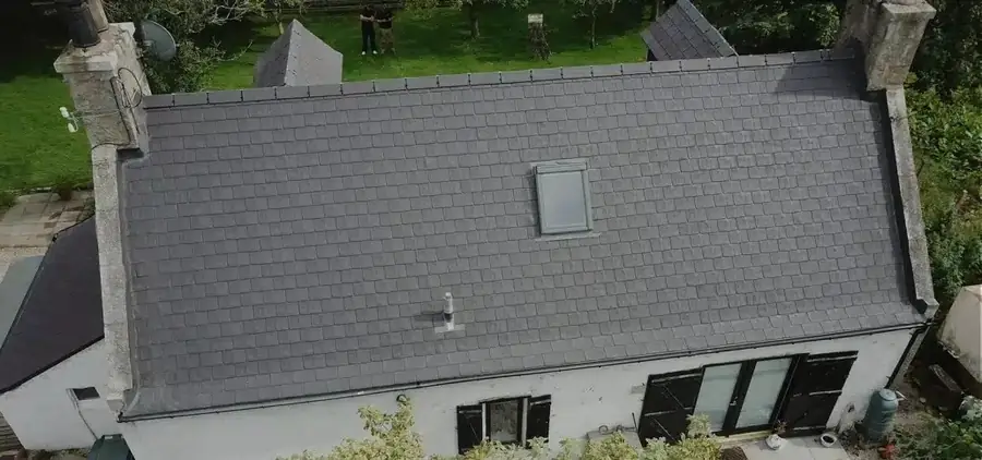 Grey tile roof finished on a bungalow with a roof window