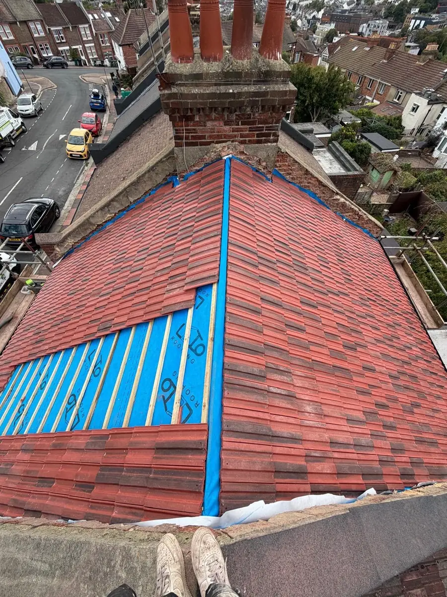 Section of a red tile roof stripped and re-membraned