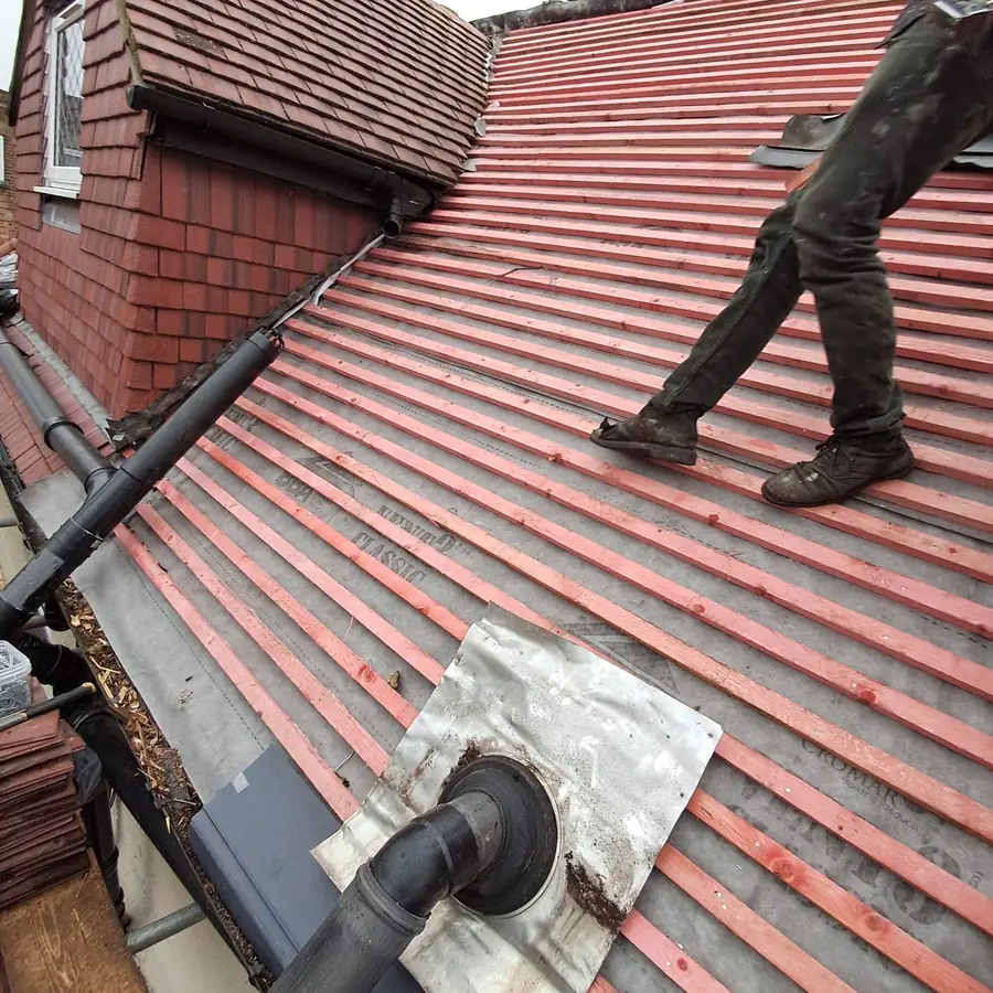 Red tile roof being battened round a vent pipe
