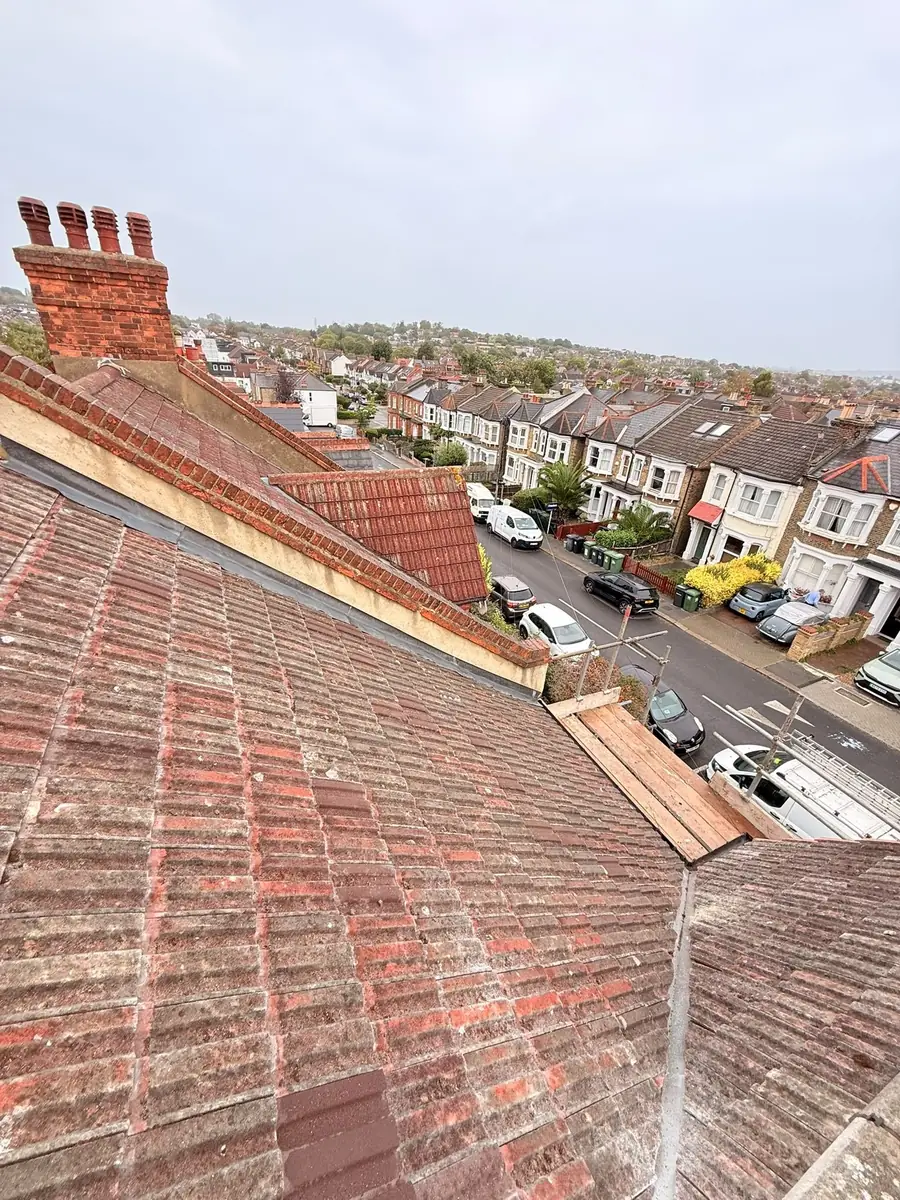Weathered terrace roof before work, chimneys alongside