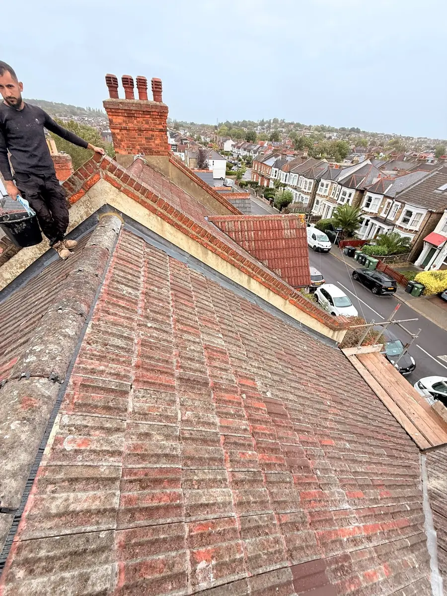Worn red tile terrace roof before work, street below